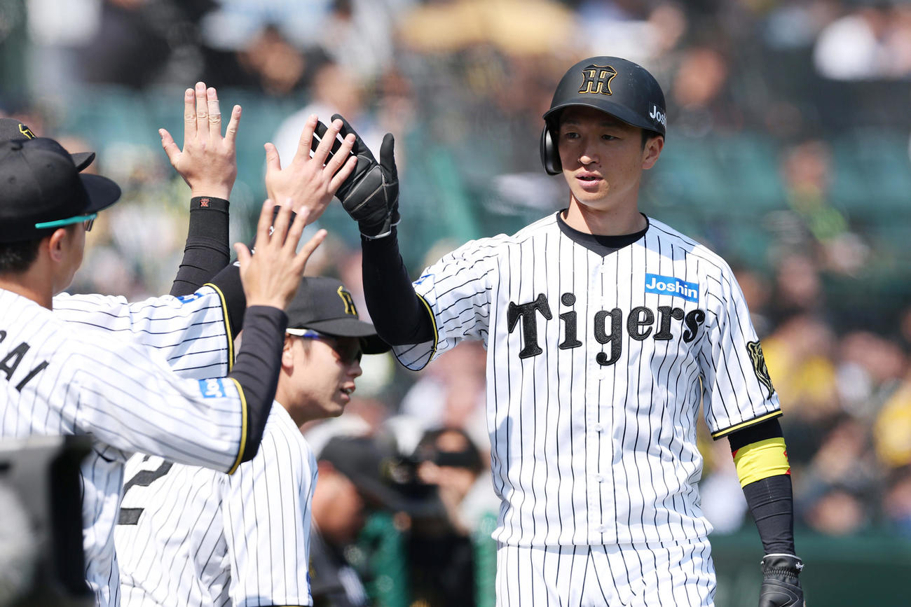 阪神対巨人　1回裏阪神2死二塁、佐藤輝の同点適時二塁打で生還しナインに迎えられる近本（撮影・前田充）