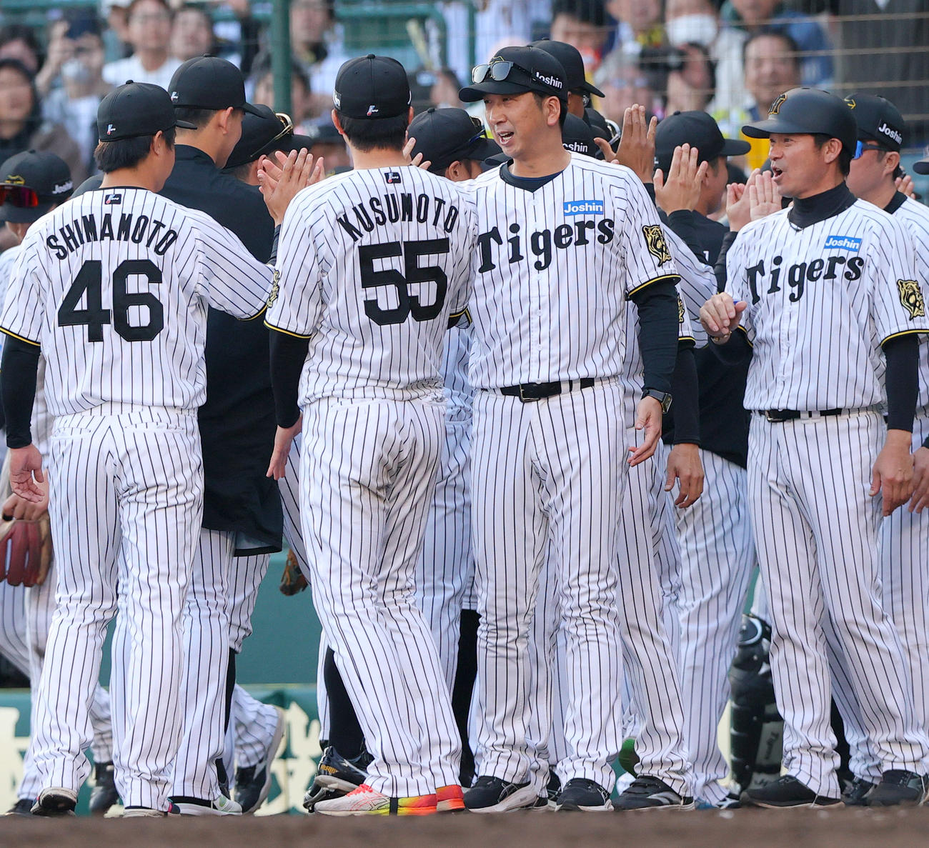 阪神対巨人　巨人に勝利した阪神藤川監督（中央）はベンチ前でナインとタッチをかわす（撮影・上山淳一）