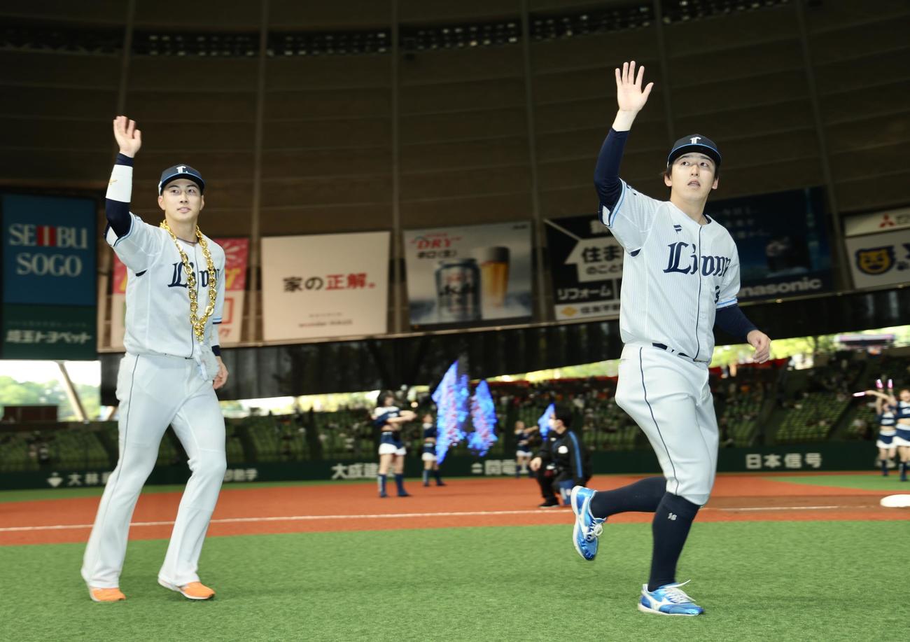 西武対オリックス　オリックスに勝利し、観客の声援に応えながら引き揚げる西武長谷川（左）と隅田（撮影・河田真司）