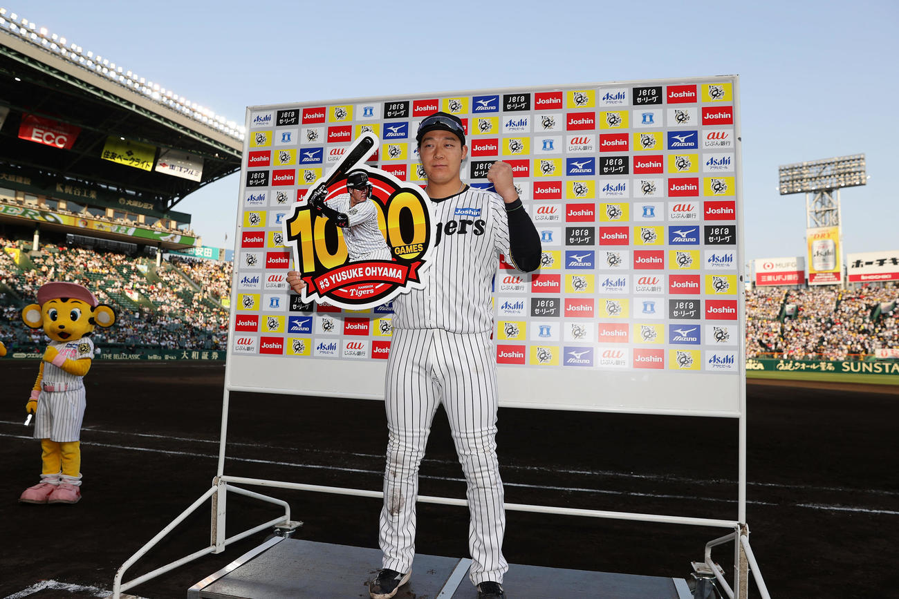 阪神対巨人　お立ち台で1000試合出場の記念ボードを手にガッツポーズする阪神大山（撮影・前田充）