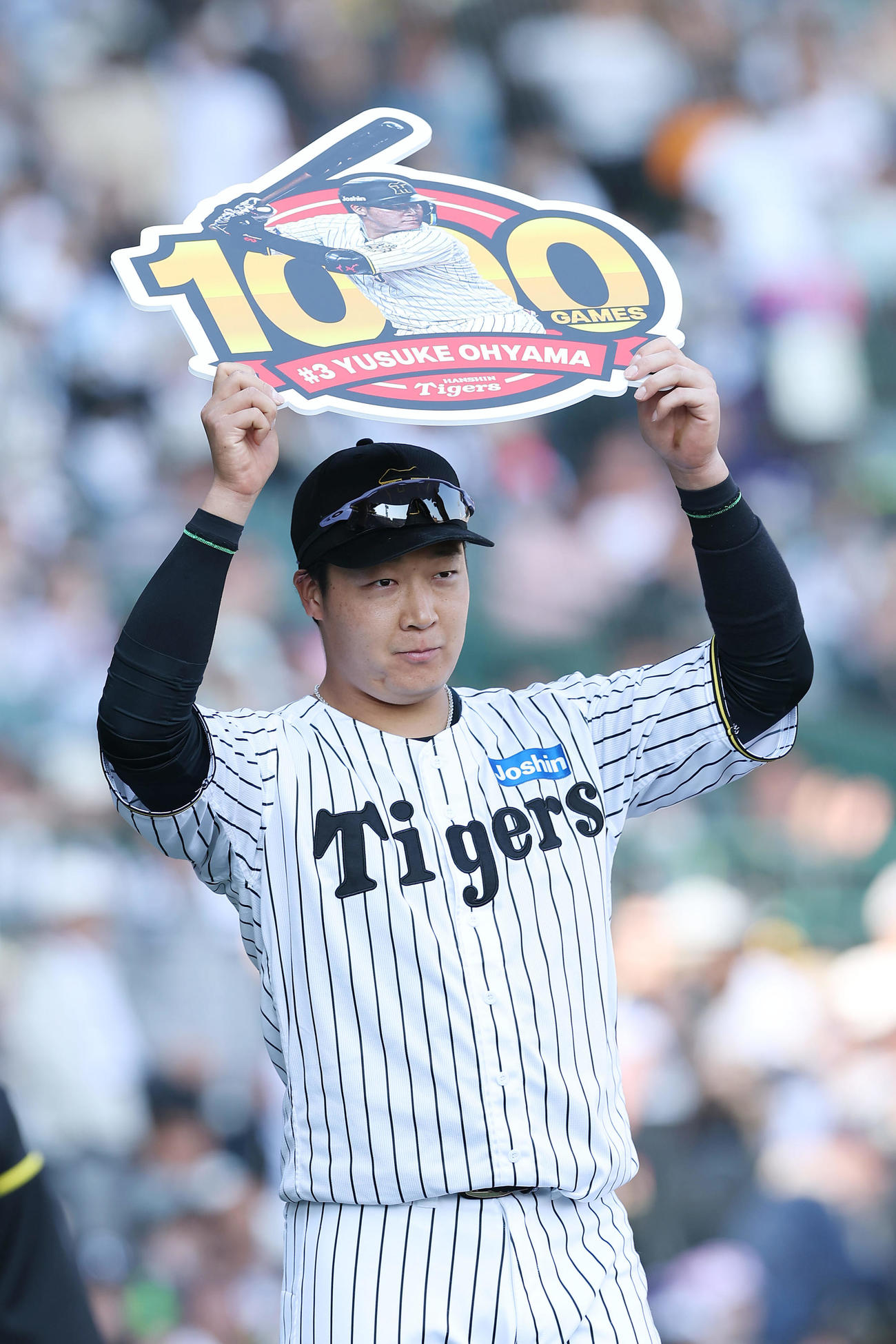 通算1000試合出場を達成し、記念ボードを掲げる阪神大山悠輔（2025年4月26日撮影）