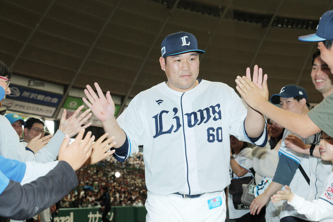 西武対オリックス　オリックスにサヨナラ勝利し、ファンとタッチを交わす西武中村剛（撮影・河田真司）
