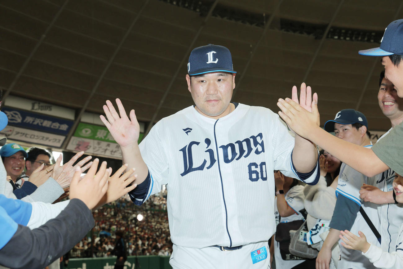 西武対オリックス　オリックスにサヨナラ勝利し、ファンとタッチを交わす西武中村剛（撮影・河田真司）