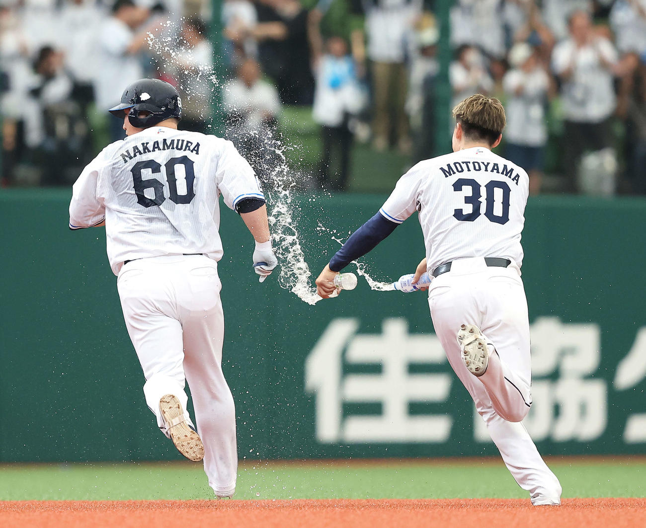 西武対オリックス　9回裏西武2死一、二塁、右前にサヨナラ適時打を放ち、チームメートの手荒い祝福から逃げる中村剛（左）（撮影・河田真司）