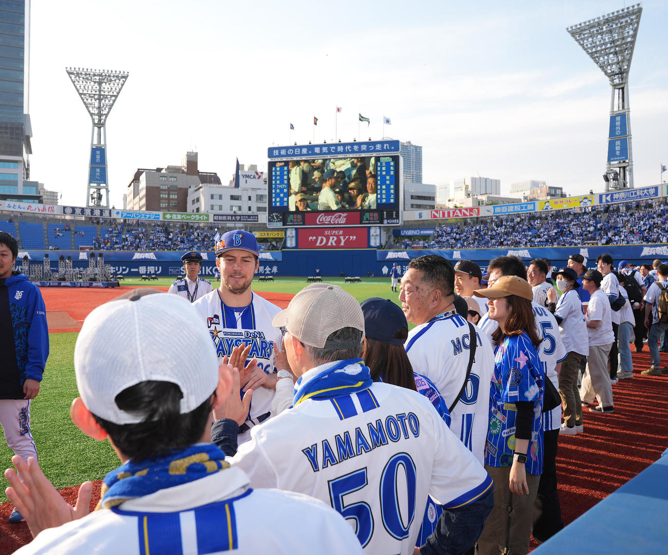 DeNA対広島　広島に3連勝し勝利投手のDeNAバウアー（左）はファンと笑顔でタッチを交わす（撮影・垰建太）