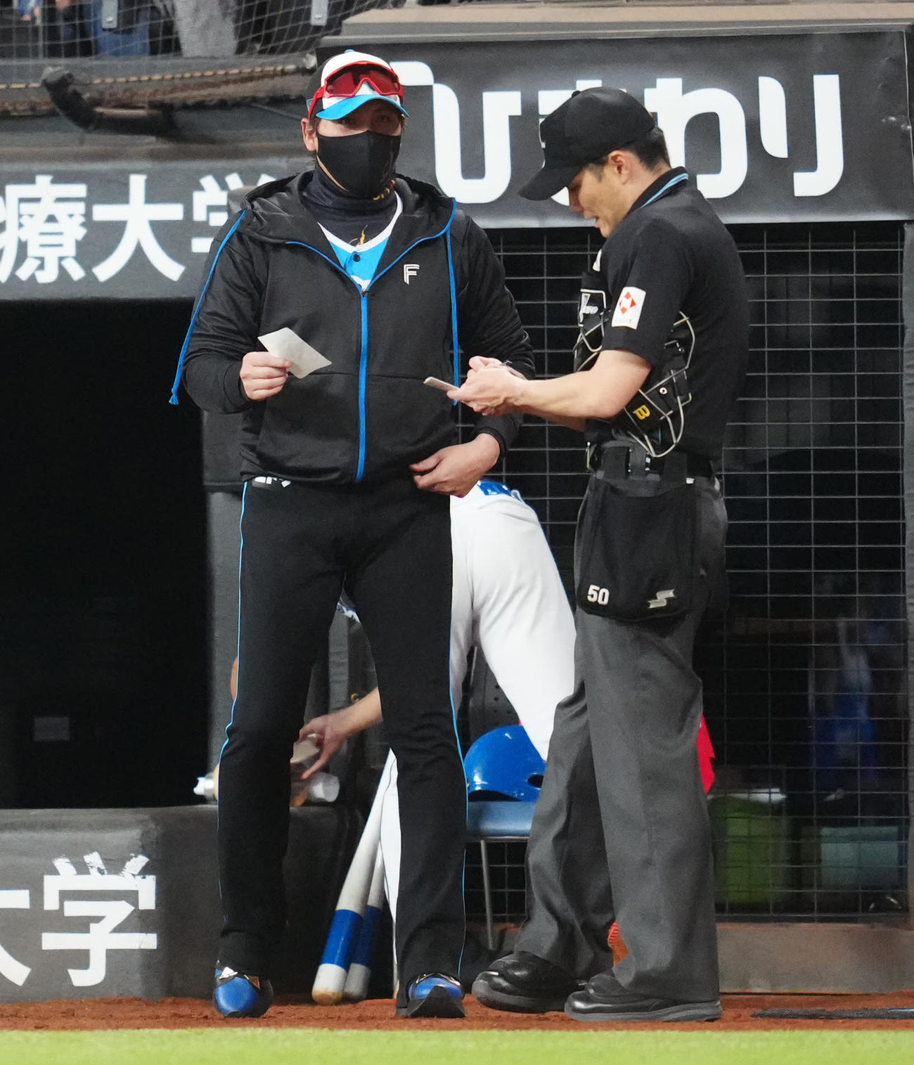 日本ハム対ロッテ　8回表開始前、選手交代を告げる日本ハム新庄監督（左）（撮影・江口和貴）