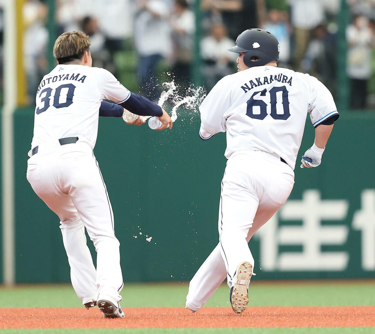 西武対オリックス　9回裏西武2死一、二塁、右前にサヨナラ適時打を放ち、チームメートの手荒い祝福から逃げる中村剛（右）（撮影・河田真司）