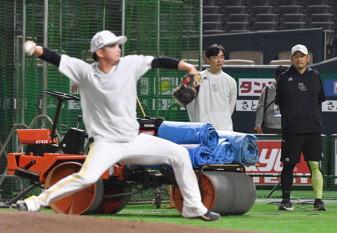 マウンドで投げ込むソフトバンク東浜（左）を見守る倉野コーチ（右）と和田アドバイザー（撮影・岩下翔太）