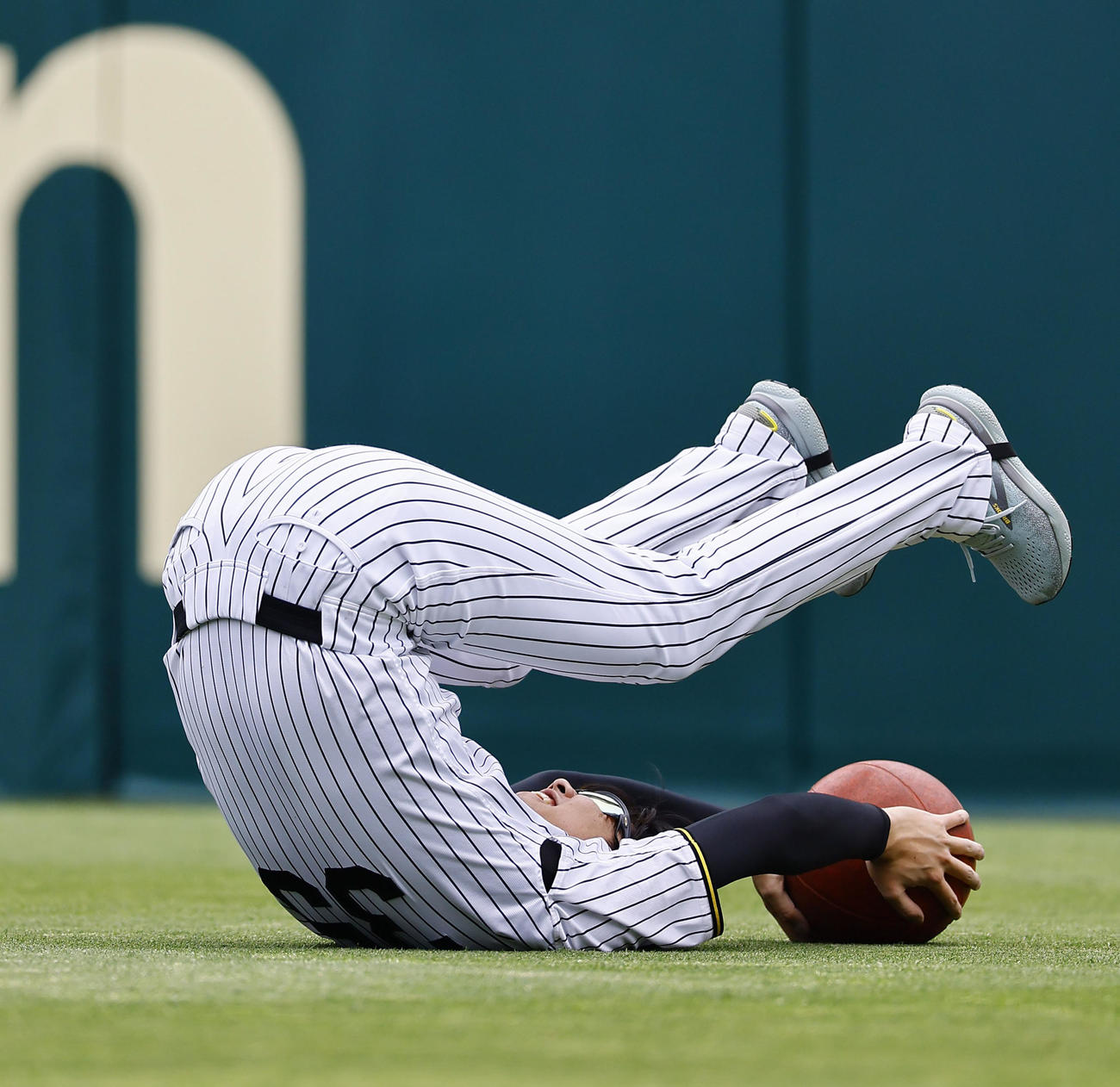 トレーニングで勢い余ってひっくり返る阪神才木（撮影・藤尾明華）