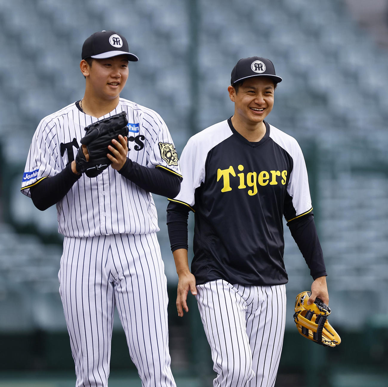 ノックで笑顔を見せる阪神門別（左）と大竹（撮影・藤尾明華）
