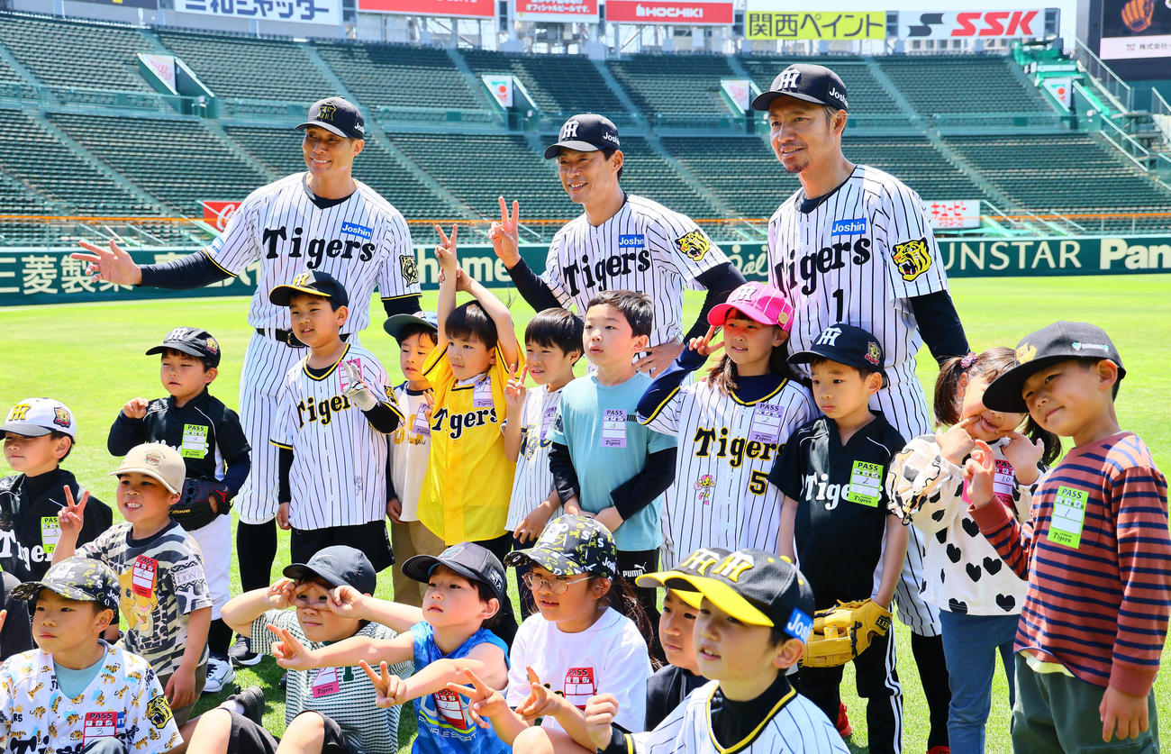 阪神OB会イベントで、子どもたちと記念写真に納まる後列左から糸井嘉男氏、桧山進次郎氏、鳥谷敬氏（撮影・藤尾明華）