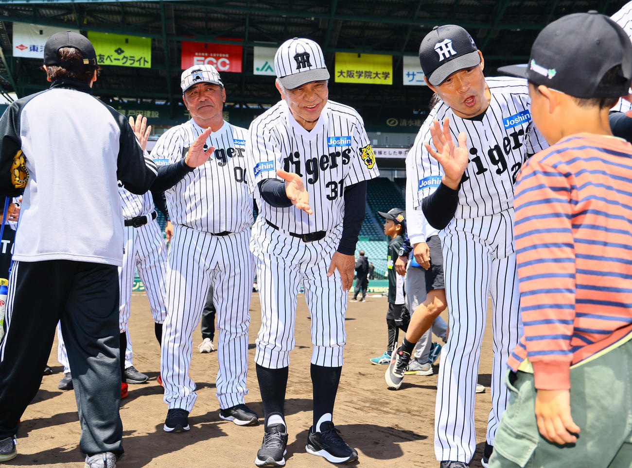 阪神OB会イベントで、参加者とタッチを交わす掛布雅之氏（中央）、桧山進次郎氏（右）ら（撮影・藤尾明華）