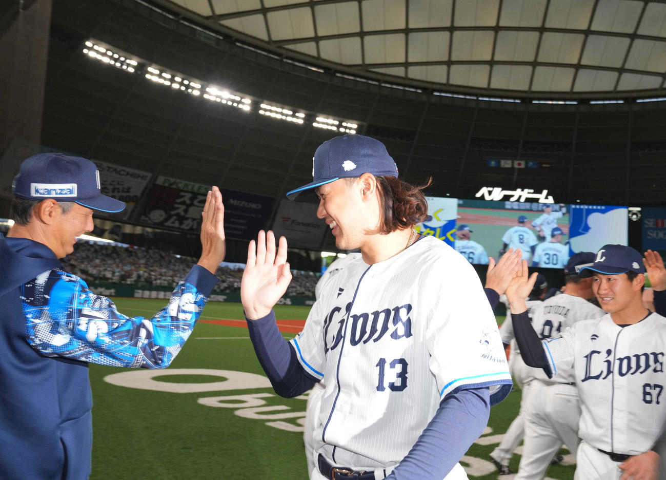 西武対楽天　597日ぶりの勝利を納め、西武西口監督（左）とタッチを交わす高橋（撮影・狩俣裕三）