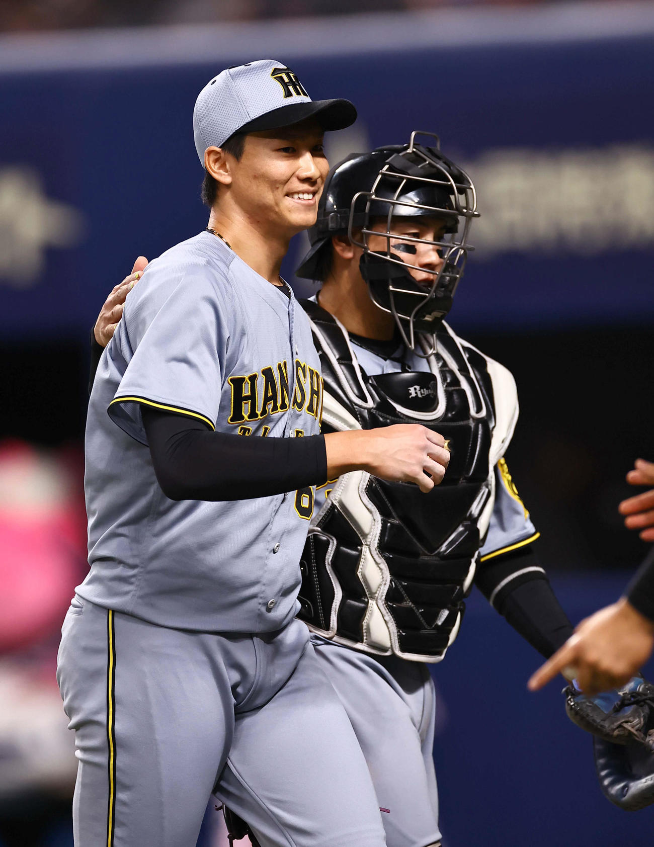 中日対阪神　8回1イニングを無失点に抑えた湯浅（左）は梅野と笑顔でベンチに引き揚げる（撮影・上田博志）