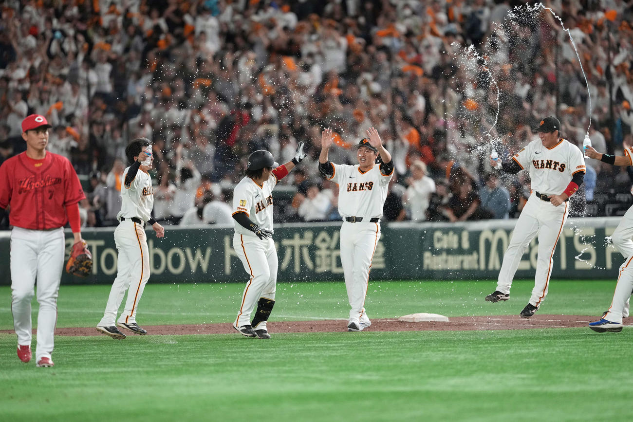 巨人対広島　サヨナラ犠飛を放った甲斐（右）はウォーターシャワーで祝福される（撮影・井上学）