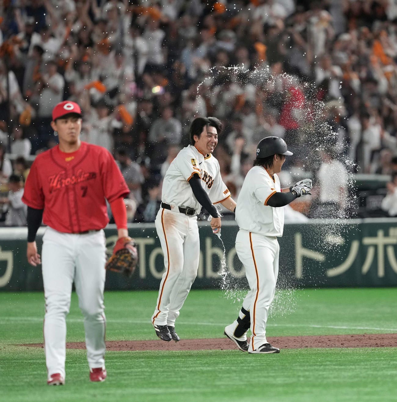 巨人対広島　サヨナラ犠飛を放った甲斐（右）はウォーターシャワーで祝福される（撮影・井上学）