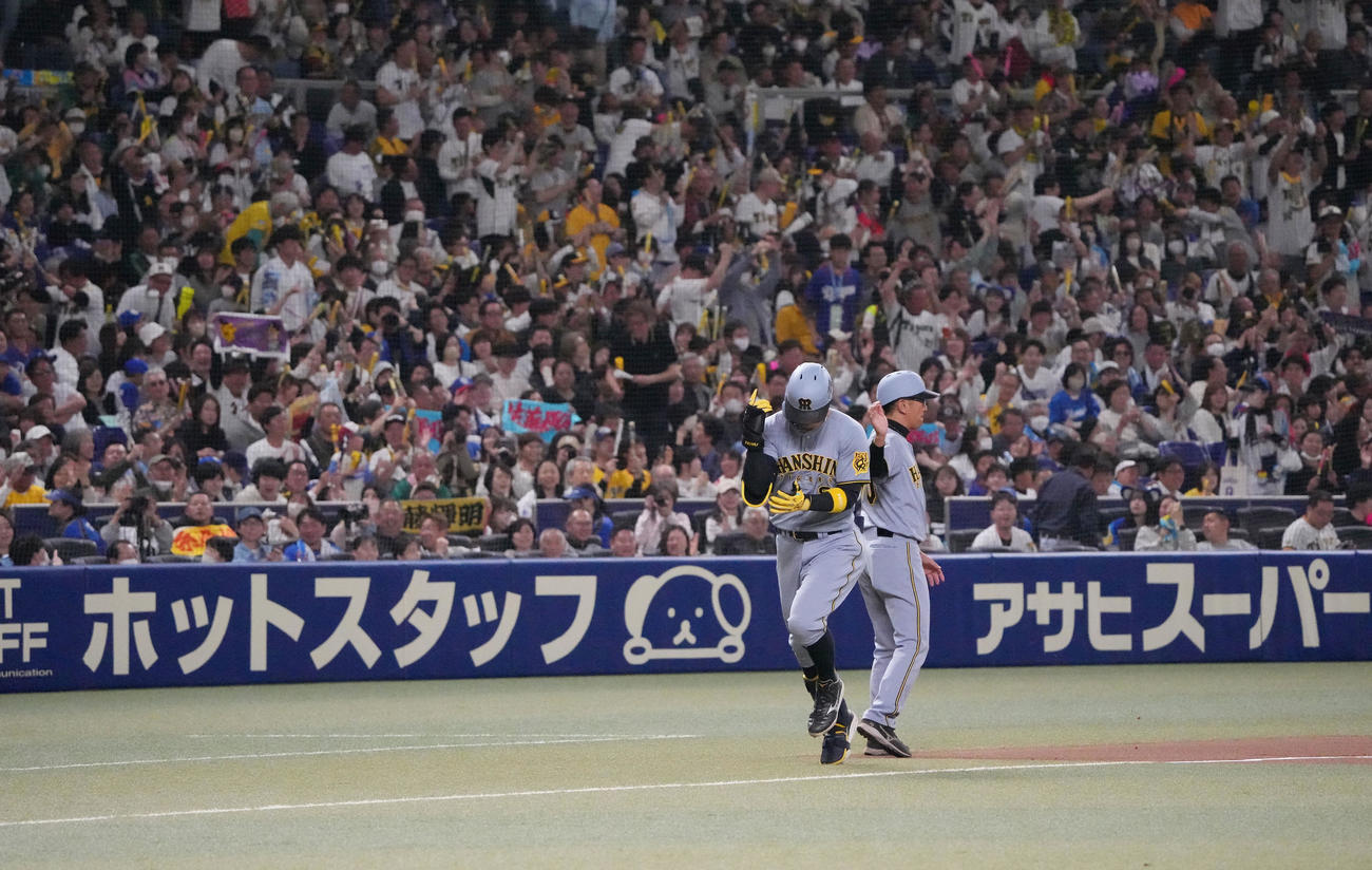 中日対阪神　4回表阪神1死、佐藤輝（左）は右越え本塁打を放ちファンの歓声を背にダイヤモンドをまわる（撮影・森本幸一）