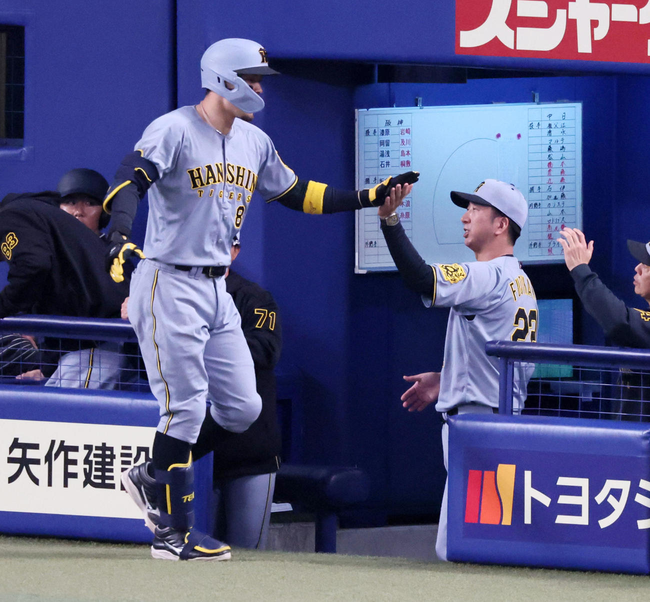 中日対阪神　4回表阪神1死、佐藤輝は右越えソロ本塁打を放ちベンチの藤川監督（右）とタッチする（撮影・加藤哉）
