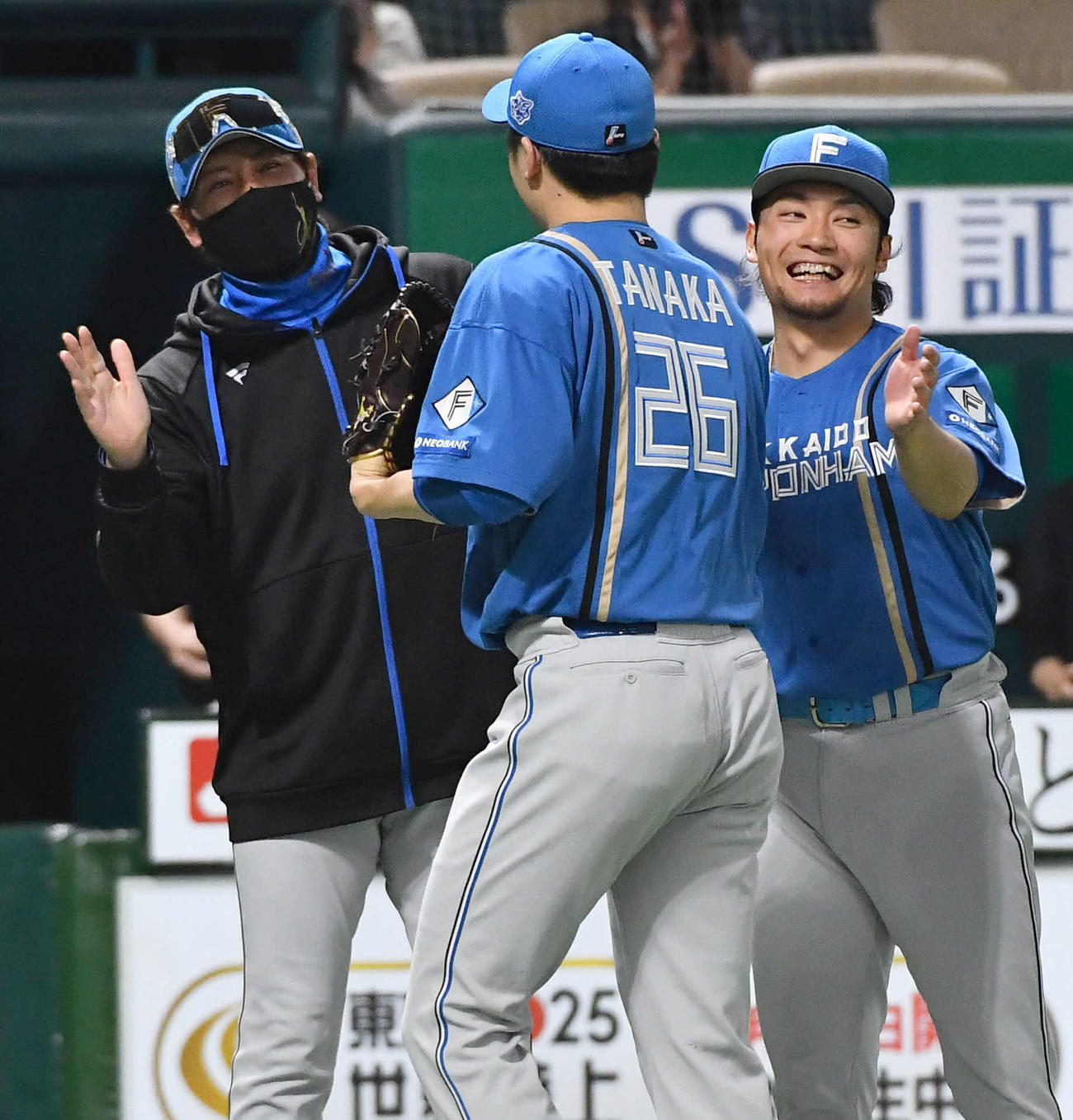 ソフトバンク対日本ハム　今季3勝目を挙げた伊藤（右）は、最終回を抑えた田中と笑顔でタッチを交わす。左は新庄監督（撮影・岩下翔太）