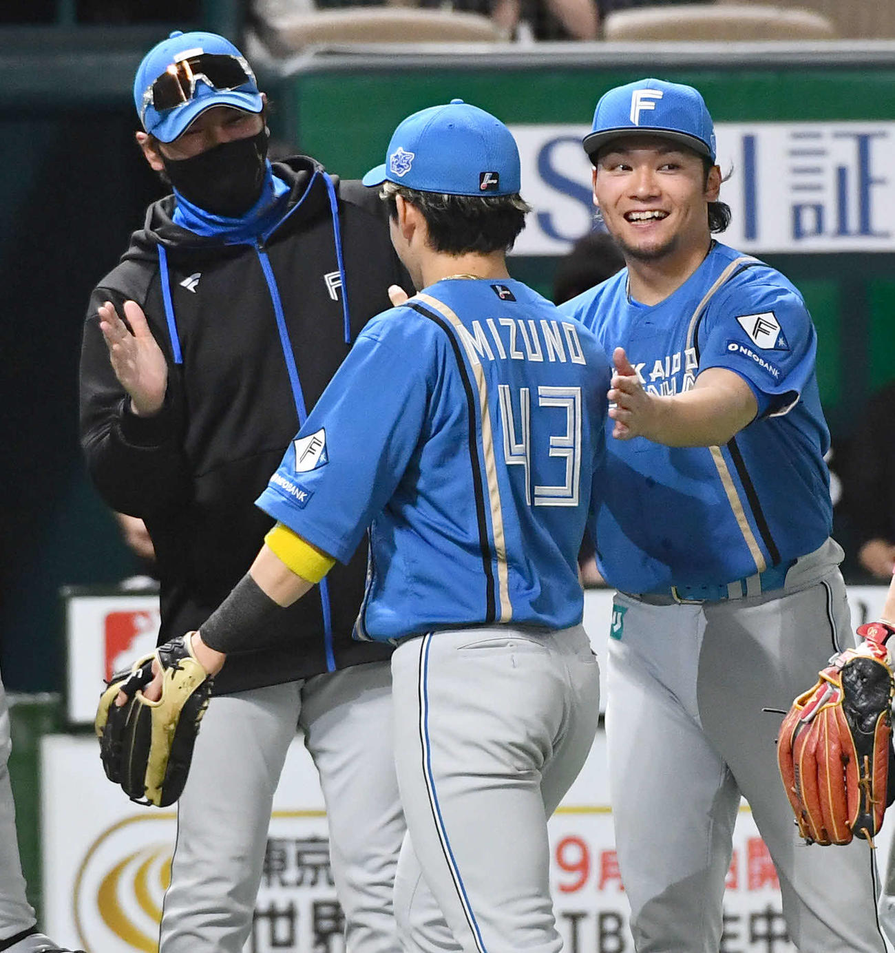 ソフトバンク対日本ハム　今季3勝目を挙げた伊藤（右）は、決勝本塁打を放った水野と笑顔でタッチを交わす。左は新庄監督（撮影・岩下翔太）