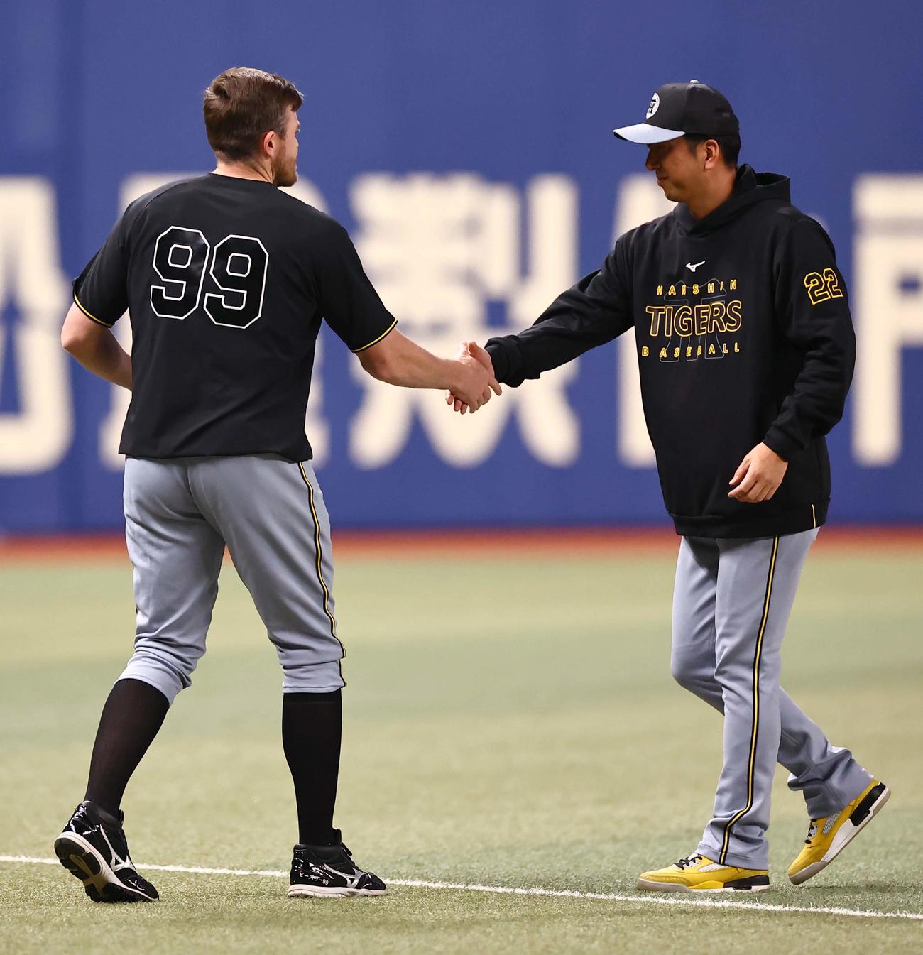 中日対阪神　1軍に合流したビーズリー（左）は藤川監督と握手を交わす（撮影・上田博志）