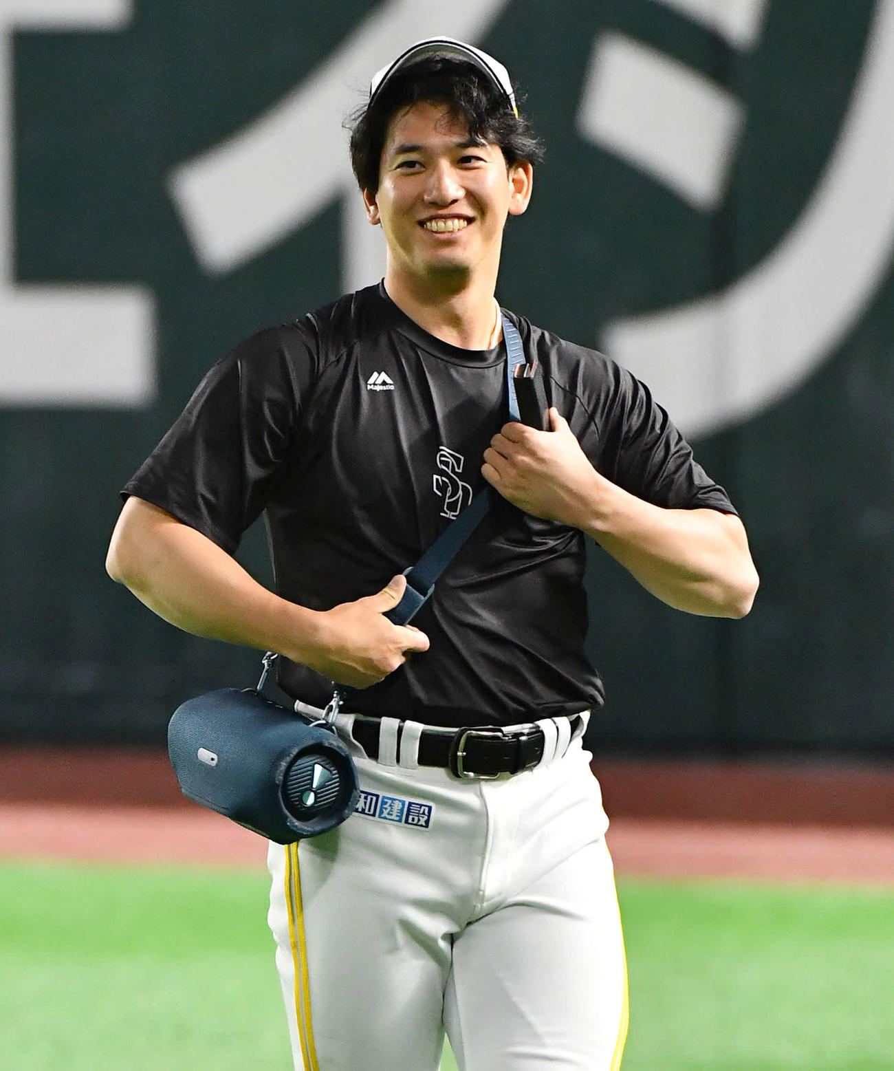 ソフトバンク対日本ハム　肩からスピーカーをかけて笑顔を見せる栗原（撮影・岩下翔太）