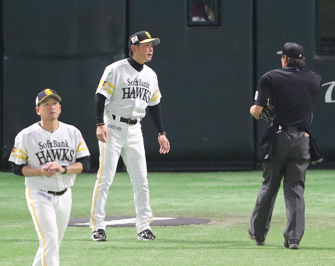 ソフトバンク対日本ハム　4回途中、審判に投手交代を告げる小久保監督、左は倉野コーチ（撮影・梅根麻紀）