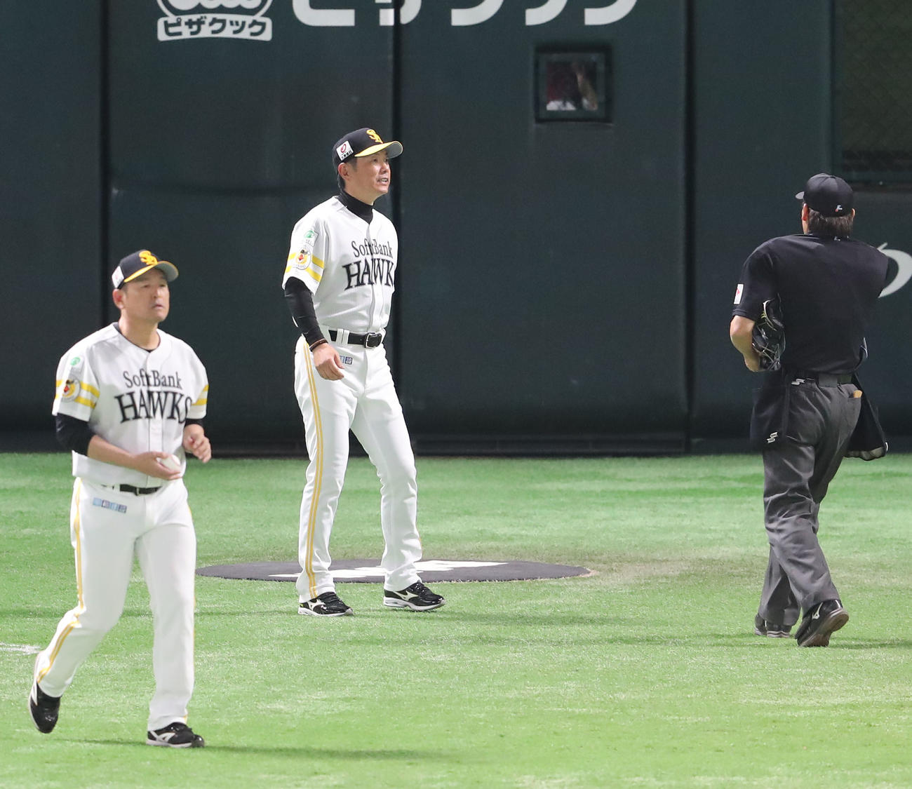ソフトバンク対日本ハム　4回途中、審判に投手交代を告げる小久保監督、左は倉野コーチ（撮影・梅根麻紀）