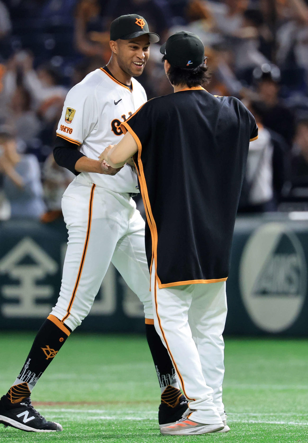 巨人対広島　開幕無失点リーグ新記録を更新して4勝目を上げた巨人山崎（手前）は最後を締めたマルティネスからウイニングボールを受け取る（撮影・浅見桂子）