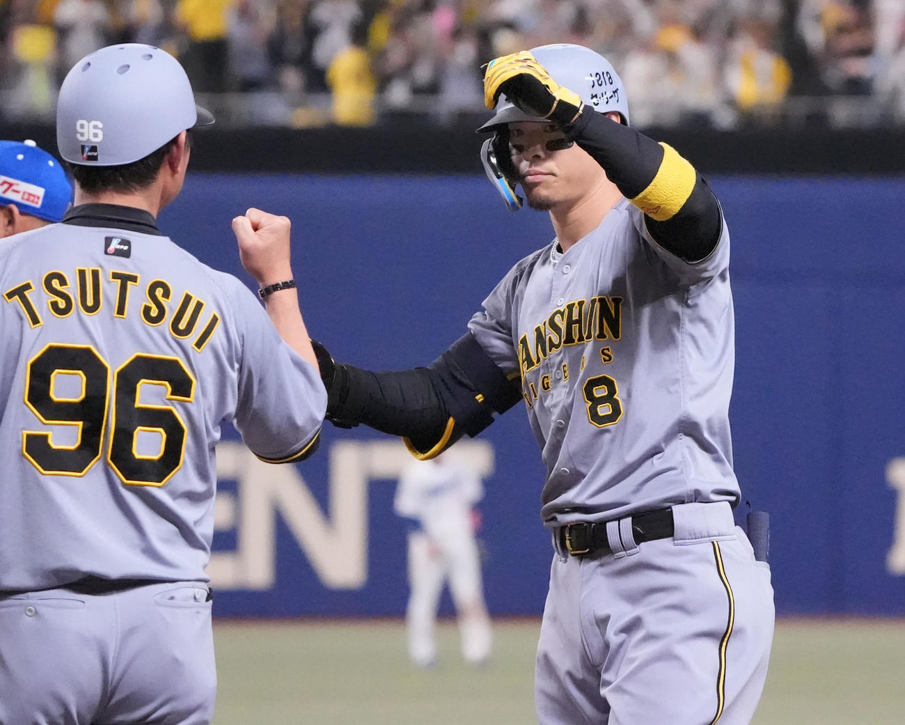 中日対阪神　6回表阪神無死満塁、左前適時打を放った佐藤輝明（右）は筒井壮外野守備兼走塁コーチとタッチを交わす（撮影・森本幸一）