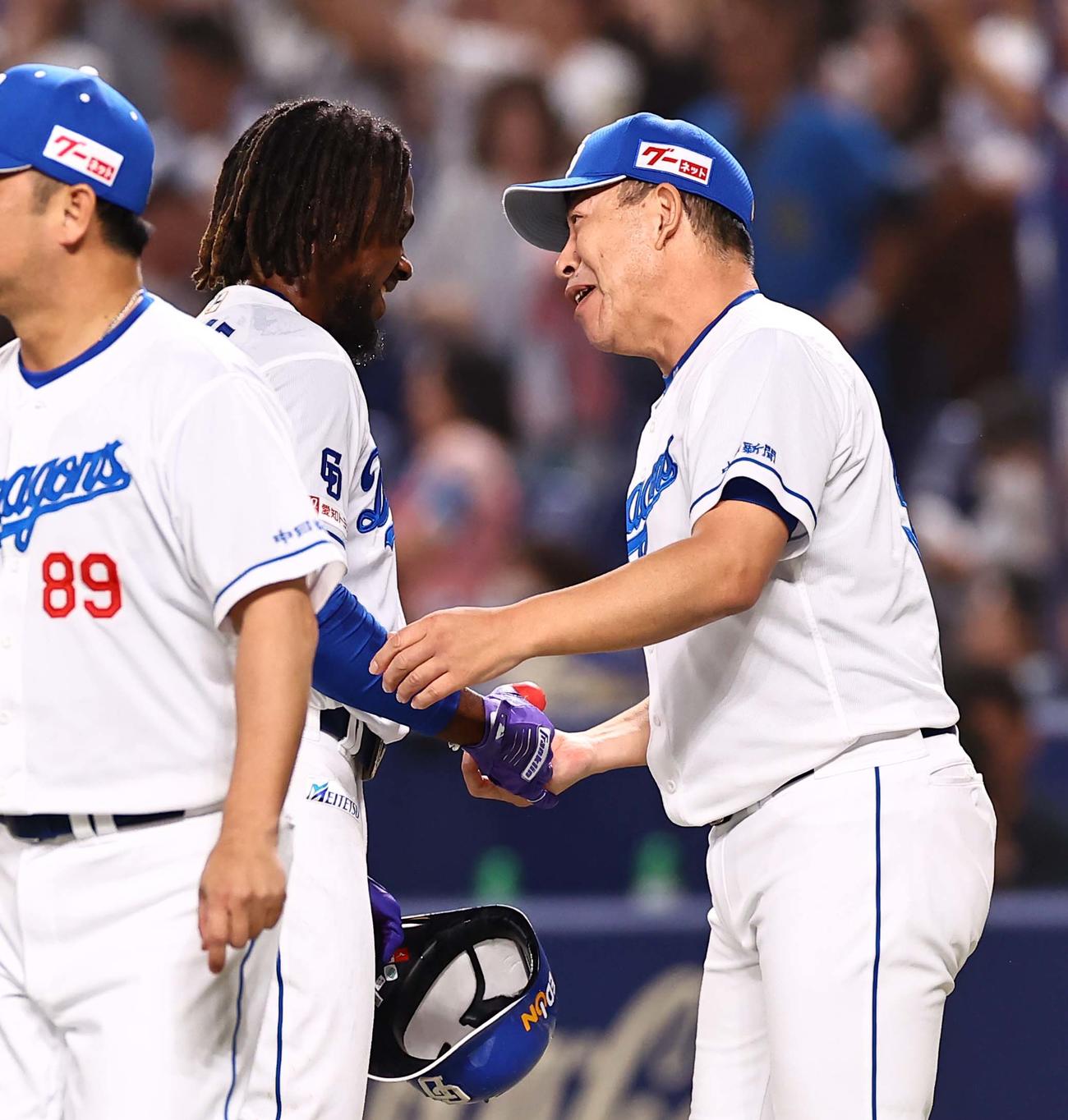 中日対阪神　11回、サヨナラ犠飛を放ったカリステ（左）と握手を交わす井上監督（撮影・上田博志）