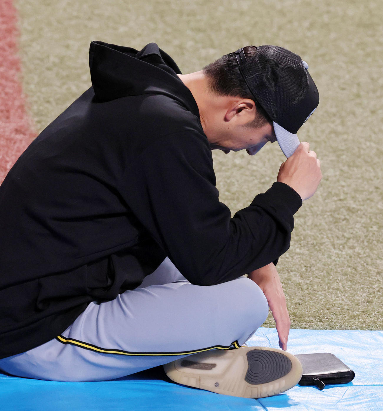 中日対阪神　練習中、外野に腰を下ろす藤川監督（撮影・加藤哉）