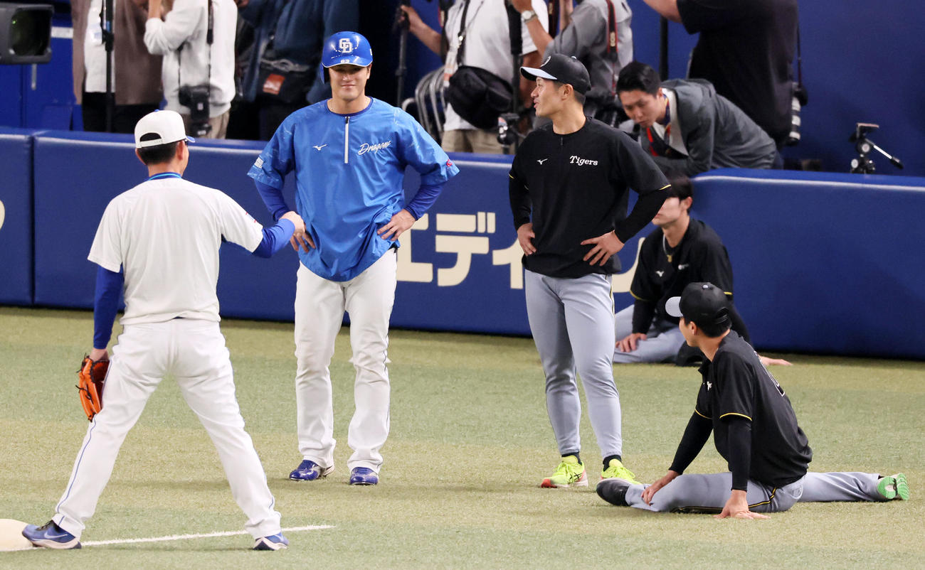 中日対阪神　練習中、中日板山（左から2人目）は阪神坂本（同3人目）と談笑（撮影・加藤哉）