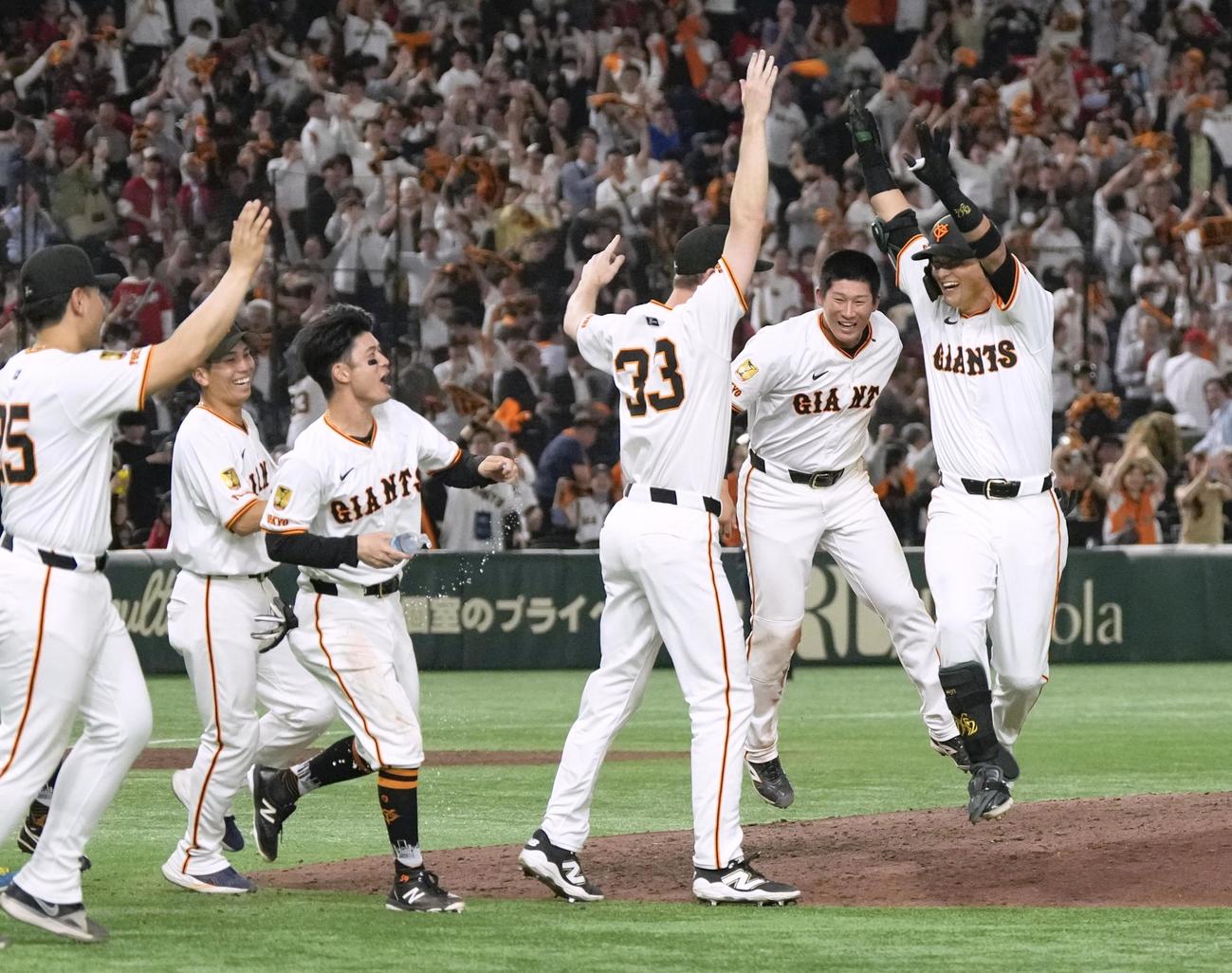 12回、サヨナラ三塁打を放ち、チームメートから祝福を受ける巨人吉川（右端）（共同）