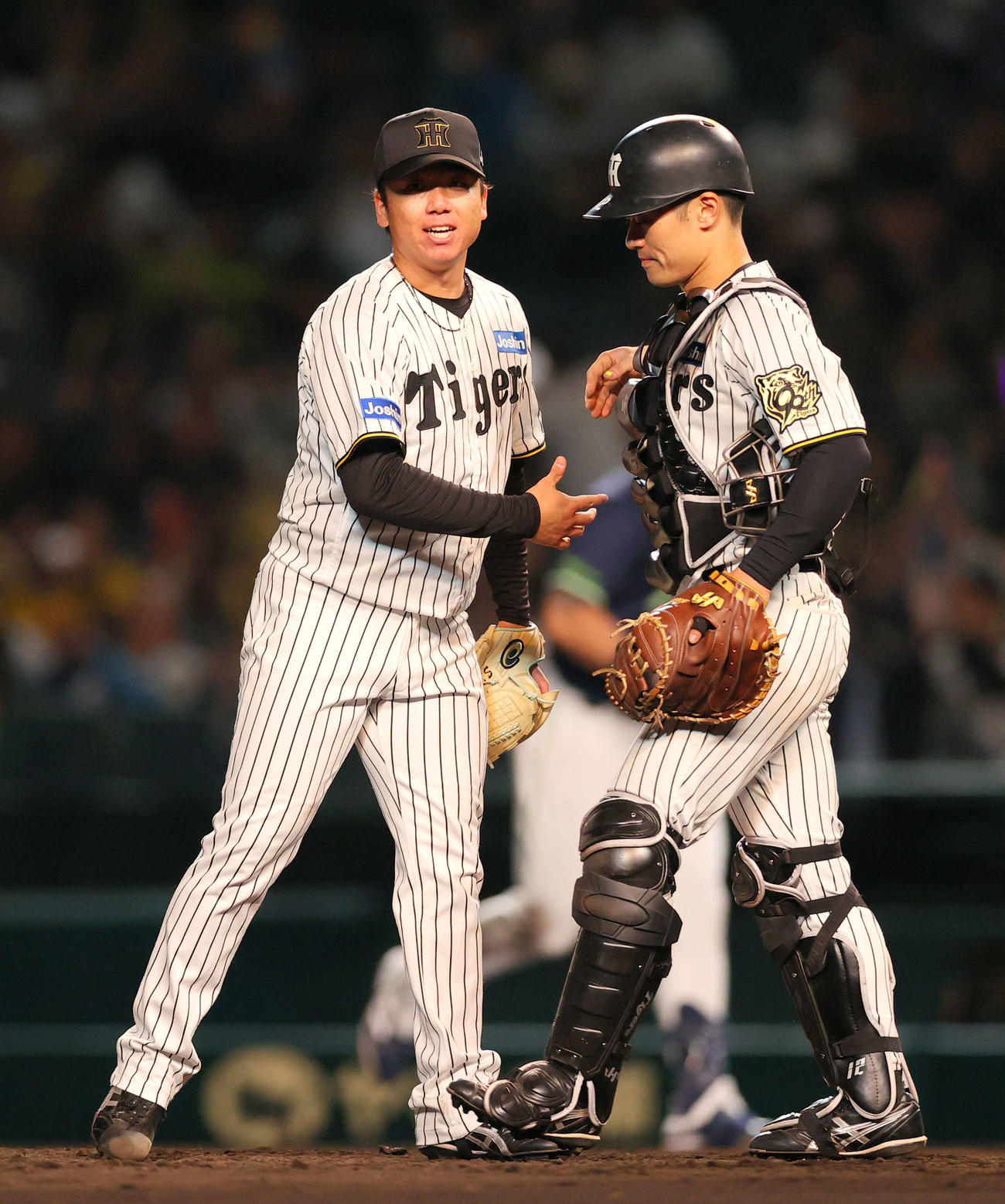 阪神対ヤクルト　ヤクルト打線を5安打完封した村上（左）は捕手坂本と握手をかわし笑顔を見せる（撮影・上山淳一）