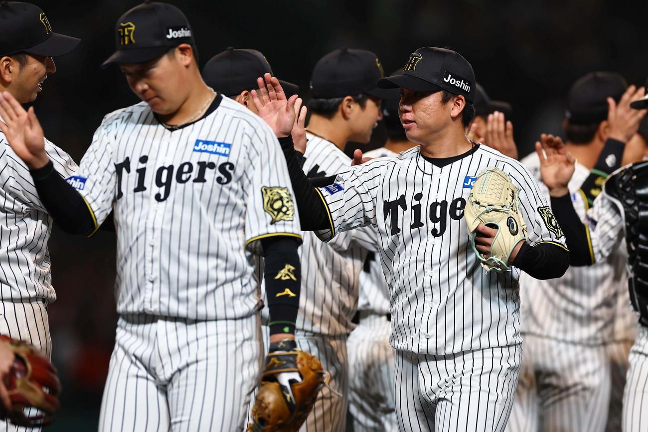 阪神対ヤクルト　5勝目をあげた村上は藤川監督（左）らナインとハイタッチをして喜ぶ（撮影・上田博志）