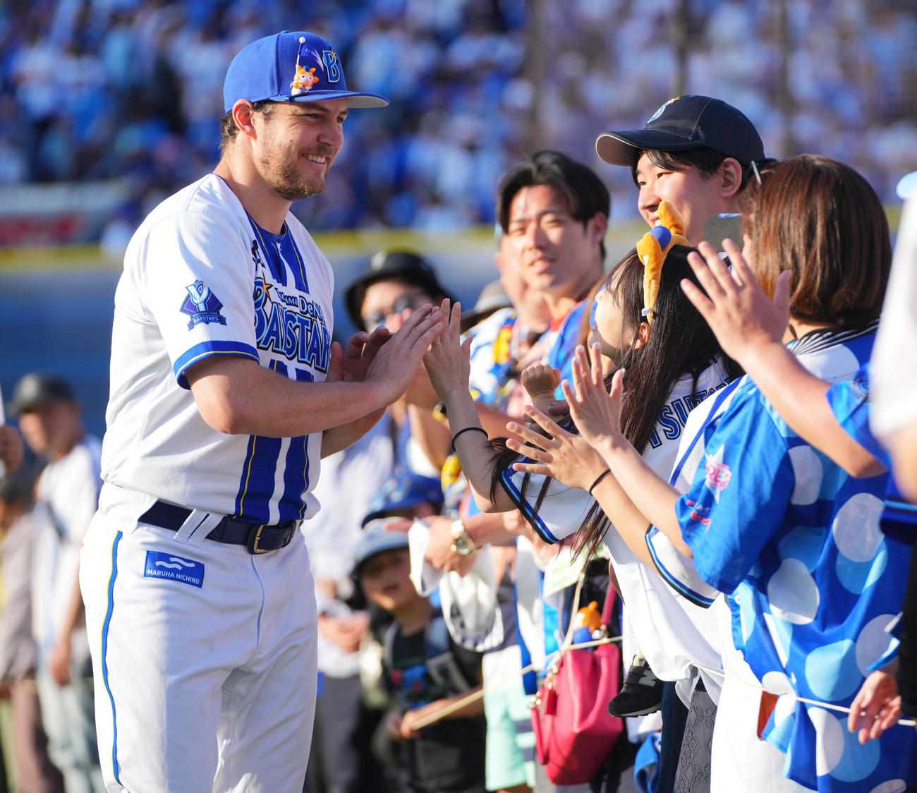 DeNA対巨人　ヒーローインタビューを終えファンと笑顔でタッチを交わすDeNAバウアー（撮影・垰建太）