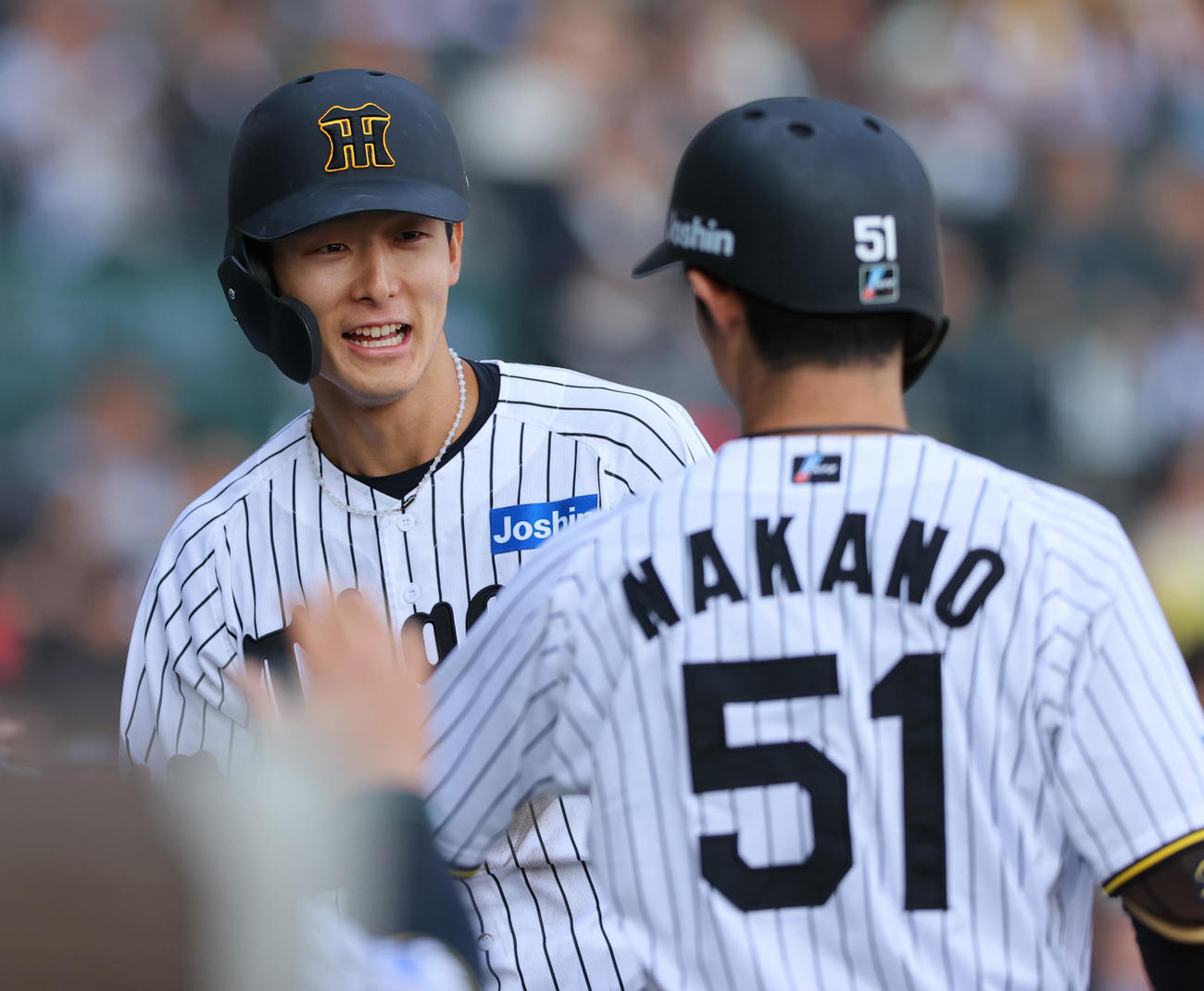 阪神対ヤクルト　6回裏阪神1死満塁、小幡（左）は中野の左犠飛で生還しベンチ前で笑顔で出迎える（撮影・上山淳一）