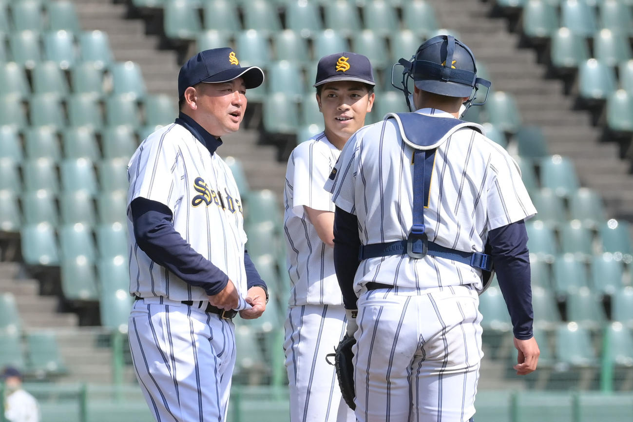 大産大対甲南大　7回裏2死二塁、マウンドへかけよる大産大の市川監督（左）（撮影・滝沢美穂子）
