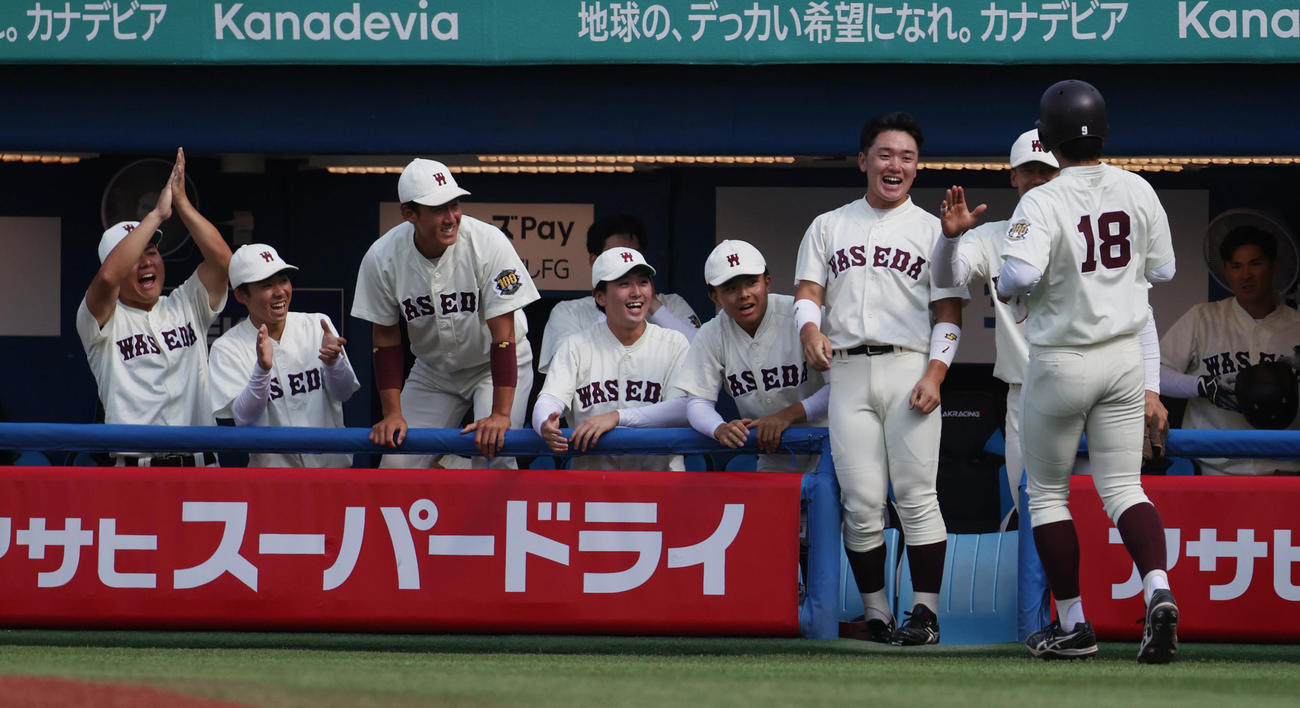 立大対早大　5回裏早大2死一、二塁、小沢の右前適時打で二塁走者宮城が生還しナインの出迎えを受ける（撮影・柴田隆二）