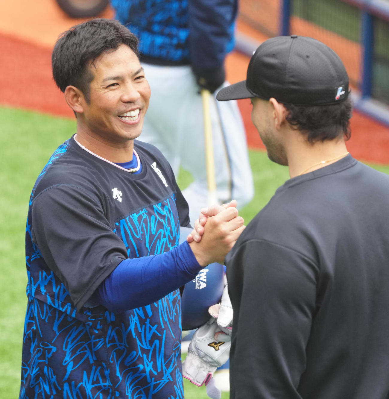 試合前練習中、握手を交わすロッテ・ソト（右）とDeNA桑原（2025年3月）