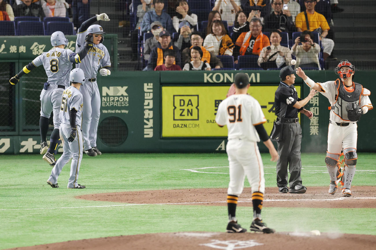 巨人対阪神　9回表阪神無死二、三塁、右越え3点本塁打を放ち森下（奥右）と喜ぶ佐藤輝（撮影・野上伸悟）