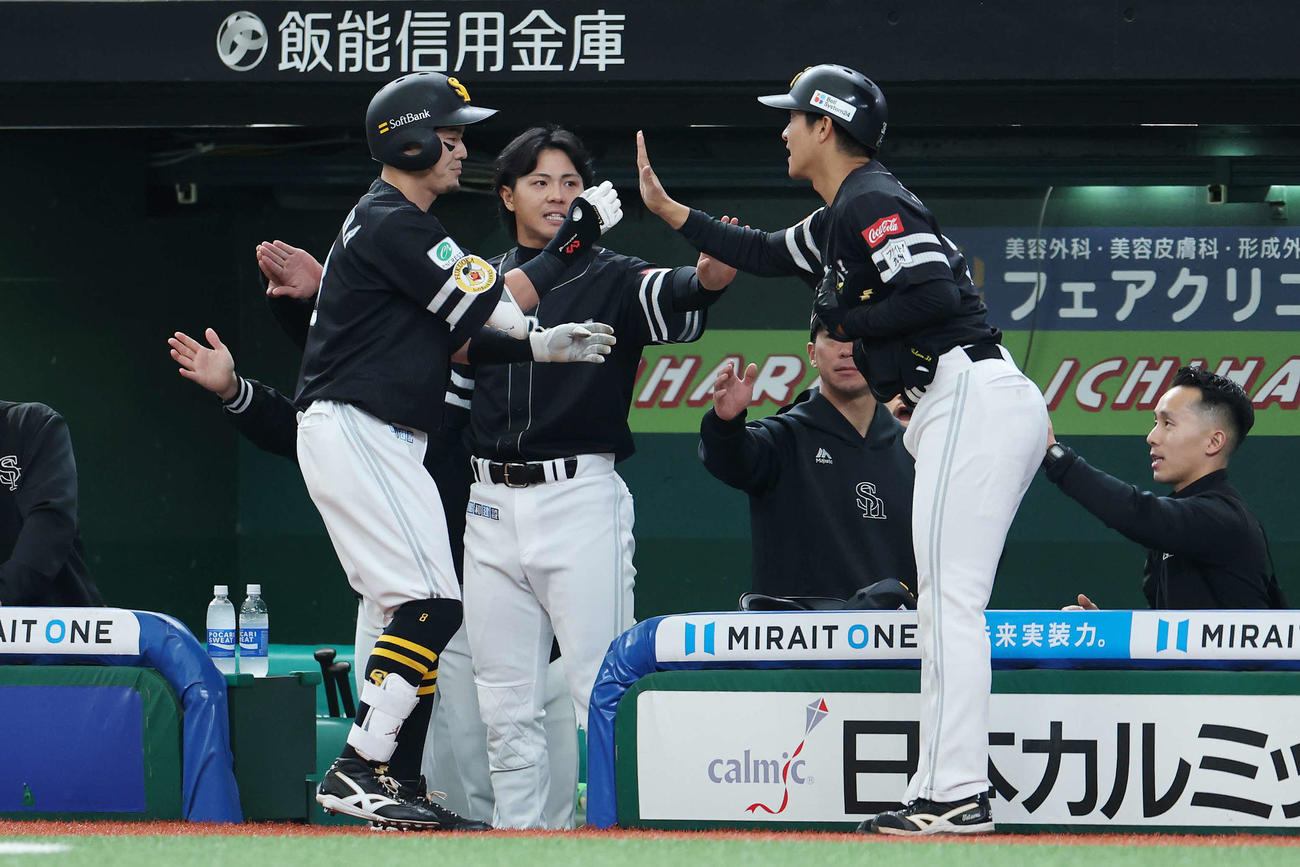 西武対ソフトバンク　1回表ソフトバンク1死満塁、牧原大（左）の右犠飛で生還しタッチする柳町（撮影・宮地輝）