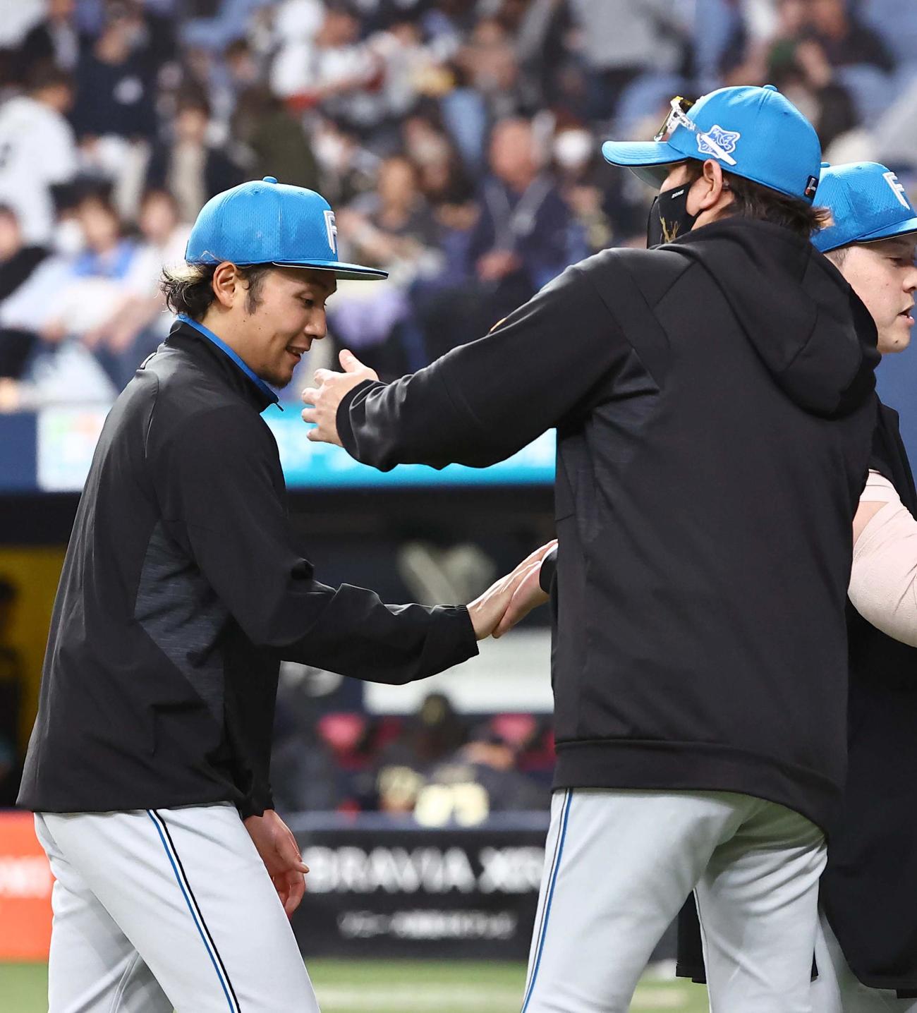 オリックス対日本ハム　4勝目をあげた伊藤（左）は新庄監督の出迎えを受ける（撮影・上田博志）