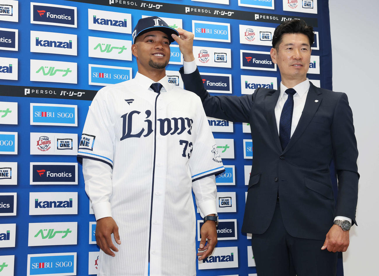 支配下登録され西武広池球団本部長（右）と写真に納まる西武モンテル（撮影・宮地輝）