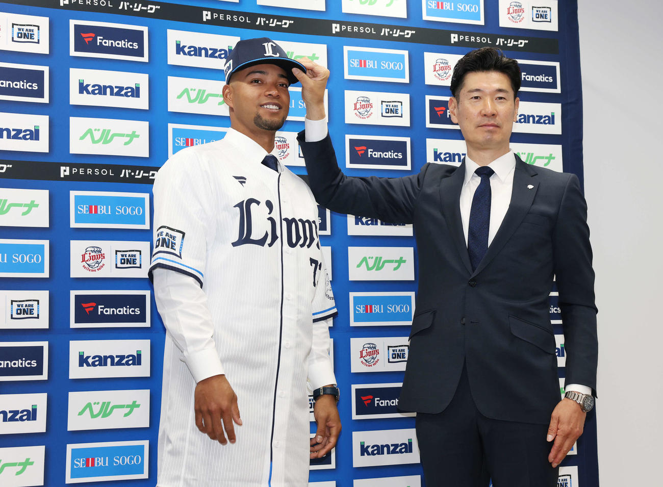 支配下登録され西武広池球団本部長（右）と写真に納まる西武モンテル（撮影・宮地輝）