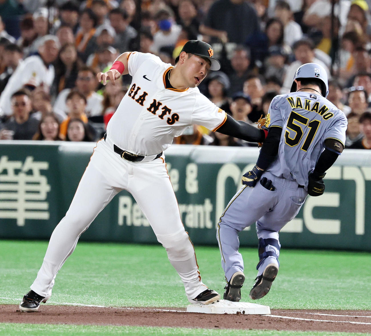 巨人対阪神　1回表阪神無死一塁、岡本は中野（右）の三塁犠打で浦田からのボールを捕球しタッチに行った際接触する（2025年5月6日撮影）