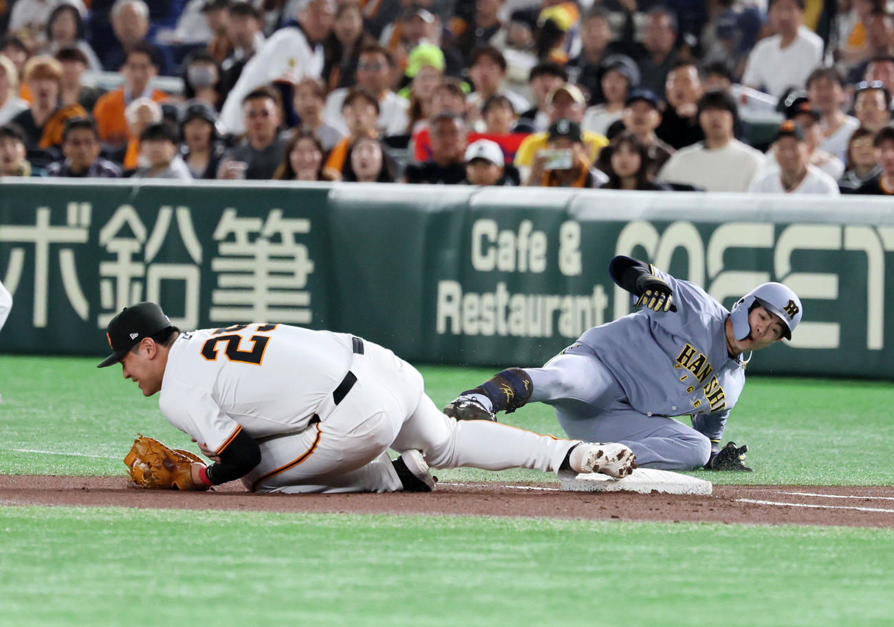 巨人対阪神　1回表阪神無死一塁、岡本は中野（右）の三塁犠打で浦田からのボールを捕球しタッチに行った際接触する（2025年5月6日撮影）