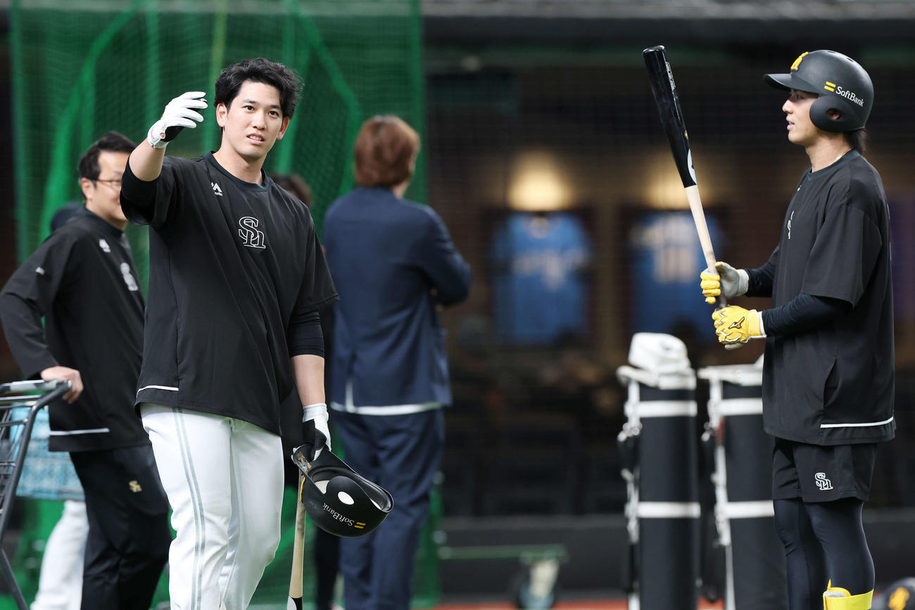 西武対ソフトバンク　試合前、ソフトバンク佐藤直（右）と言葉を交わす栗原（撮影・宮地輝）