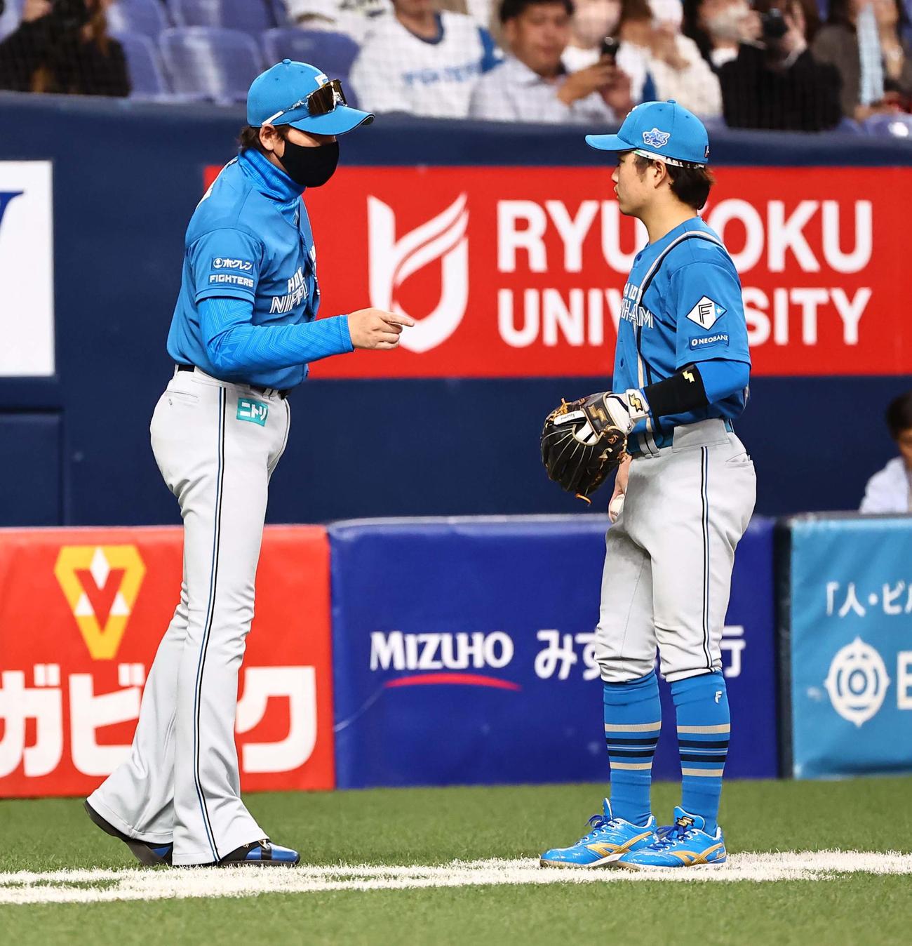 オリックス対日本ハム　12回裏オリックス1死、生田目の負傷後、三塁手の奈良間（右）と話をする新庄監督（撮影・上田博志）